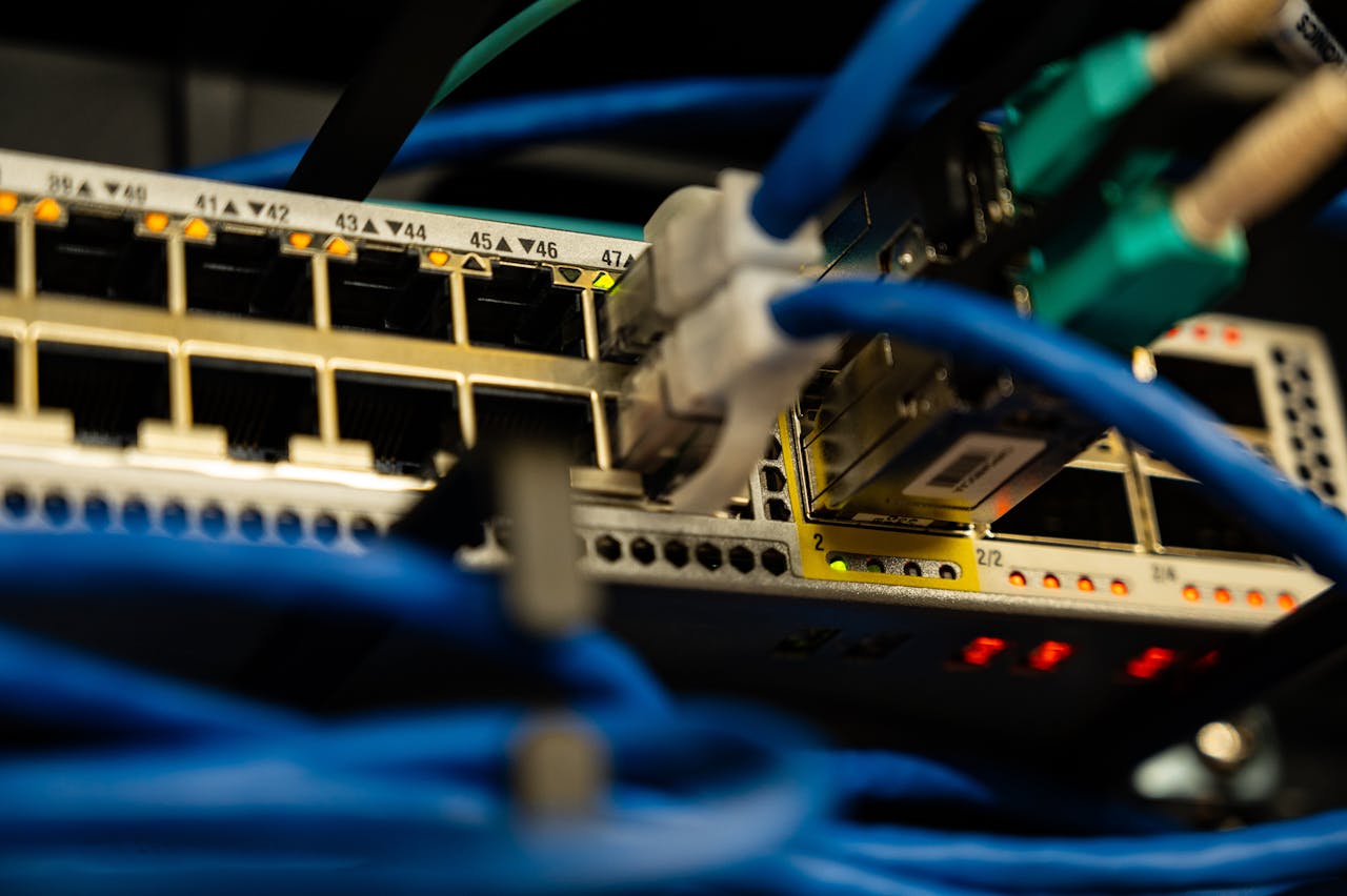 services-04 Close-up image of ethernet cables plugged into a network switch, showcasing IT infrastructure.